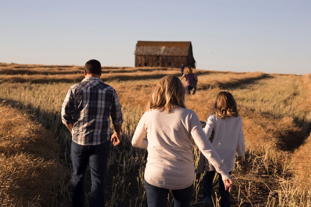 family walking through a filed of grass