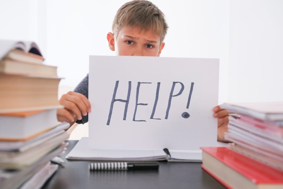 child holding a help sign